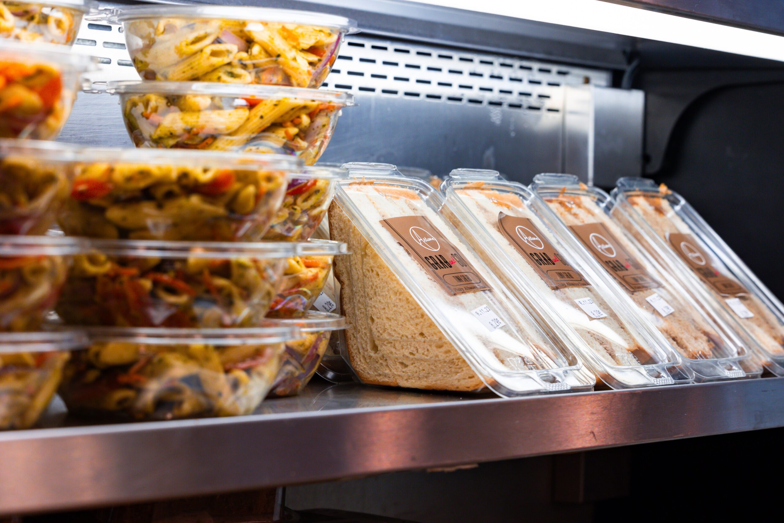 Pre-packaged sandwiches and salads in a refrigerated display case at Ocean City Moms.
